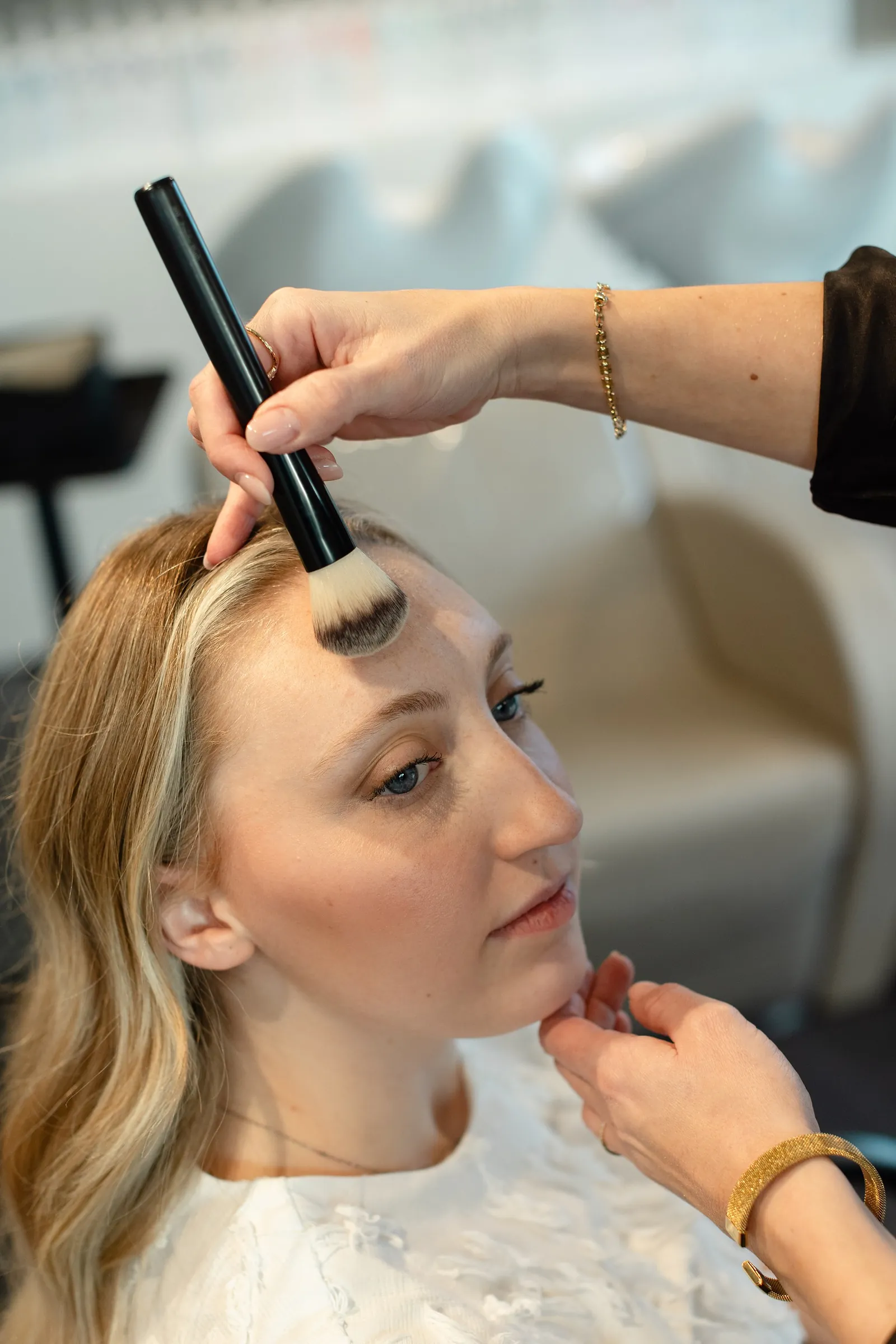 Een klant krijgt make-up in het salon